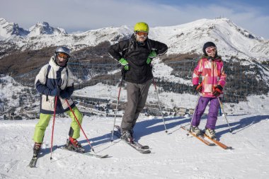 Aile, Alplerdeki İtalyan kayak merkezindeki inişten önce yamaçta. okul tatili