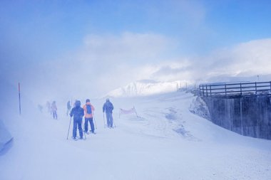 Kayakçı ailesi, Alplerde kötü havada bir geçiş rotası boyunca ilerler. tatil güvenliği