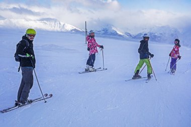 Aile, Alplerdeki İtalyan kayak merkezindeki inişten önce yamaçta. okul tatili