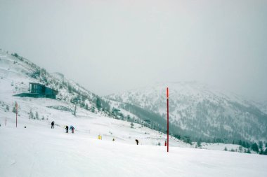 Sis ve kar, yansıtıcı işaretlerle kayak pistinin tepesinde. Aktif Boş Zaman ve Güvenlik