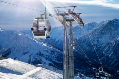 Güneşli bir günde Alplerdeki bir dağın tepesinde kayak asansörü.
