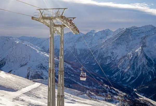 Güneşli bir günde Alplerdeki bir dağın tepesinde kayak asansörü.