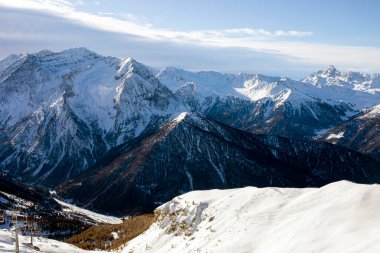 Alplerdeki bir dağın tepesinde sabah güneşinde kayak asansörü.