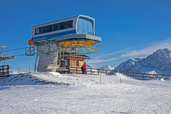 Güneşli bir günde Alplerdeki bir dağın tepesinde kayak asansörü.