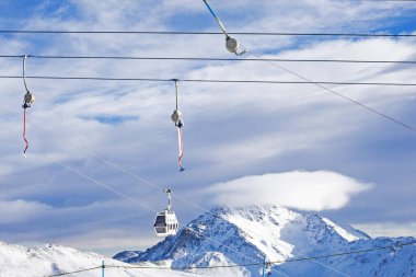 Alplerdeki İtalyan tatil beldesinin yamacında konforlu kayak asansörü sürükler.