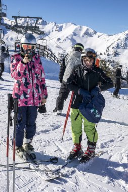 Genç kayakçılar güneşli bir günde kayak pistinde inmeden önce. aktif okul tatilleri