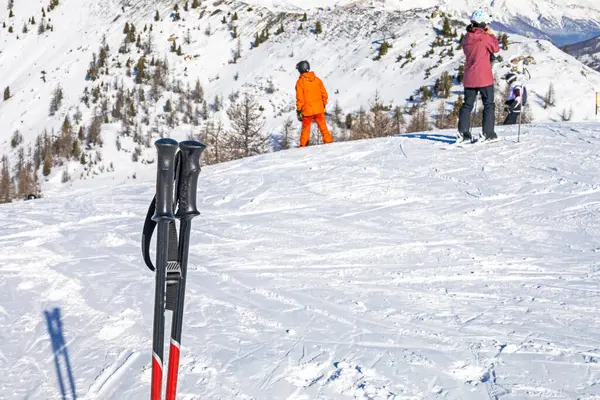  Alplerde güneşli bir günde, karlı bir yamaçta kayak direkleri