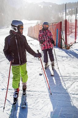Genç kayakçılar sabahın erken saatlerinde Alplerdeki İtalyan kayak merkezinde. Okul aktif tatilleri