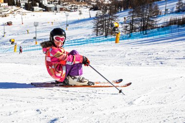 Mutlu küçük kayakçı Alplerdeki bir İtalyan tatil köyünde kapalı bir yamaçta oturur. En iyi okul tatili.