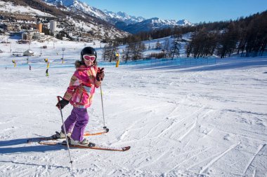 Alplerdeki İtalyan tatil köyünde küçük mutlu bir kayakçı. En iyi okul tatili.