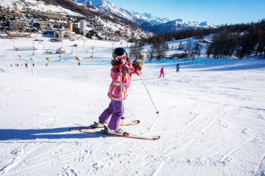 Alplerdeki bayırda küçük mutlu bir kayakçı. Okul tatili