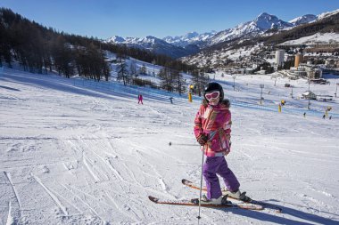 Alplerdeki İtalyan tatil köyünde küçük mutlu bir kayakçı. En iyi okul tatili.