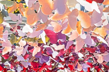 decorative multi-colored garlands with butterflies on a fishing line swaying in the wind outside: clipart