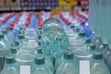 Süpermarkette farklı kapasite şişelerinde içme suyu. Sağlık hizmetleri