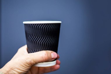 Gri arka planda siyah kabartmalı tek kullanımlık bardak. Tasarım, logolar, çizimler için maket