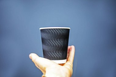 Gri arka planda siyah kabartmalı tek kullanımlık bardak. Tasarım, logolar, çizimler için maket