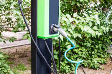 Dışarıda elektrikli araba şarj etmek için yer ve cihaz. Tasarruf, bütçe ve ekoloji