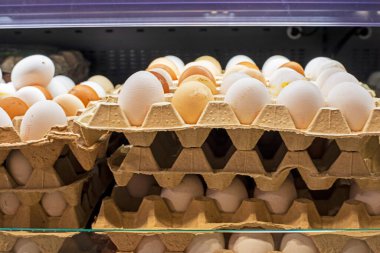 Süpermarketteki karton bir kutuda tavuk beyazı ve kahverengi yumurtalar.
