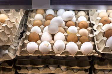 Süpermarketteki karton bir kutuda tavuk beyazı ve kahverengi yumurta. Ekonomik kriz