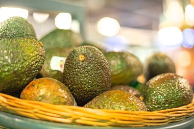 Süpermarketteki plastik kaplarda olgun avokado. Vejetaryen yemeği