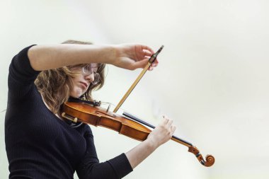 Genç kemancı kız bir öğretmenle müzik dersinde notalardan bir şeyler öğreniyor. Müzikal gelişme