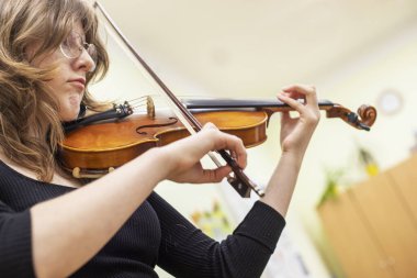  Genç kemancı kız müzik dersinde notalardan bir şeyler öğreniyor. Müzikal gelişme