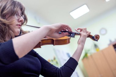 Kemancı kız müzik dersinde notalardan bir şeyler öğreniyor. Müzikal gelişme