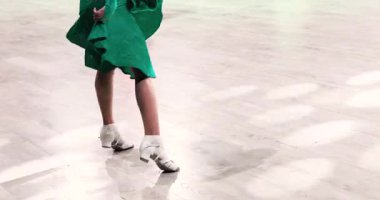 Yeşil elbiseli genç bir kız turnuvada Latin Amerika programında dans ediyor. Salon dansı..