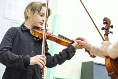 Bir müzisyenle çalmadan önce kemanlı mutlu bir kız.