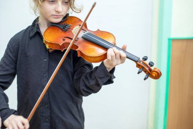 Genç kemancı kız bir öğretmenle müzik dersinde notalardan bir şeyler öğreniyor. Müzikal gelişme