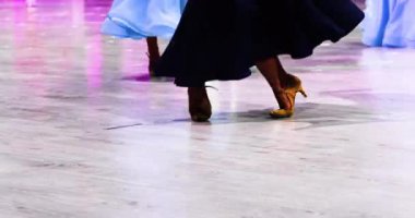 Güzel elbiseli küçük kız bir turnuvada balo salonunda standart bir dans gösterisi yapıyor.