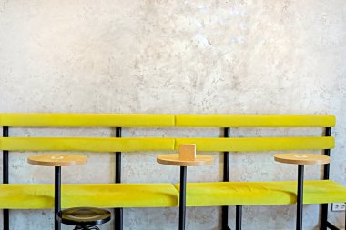 İç kısımda sarı masalar ve sandalyeler.