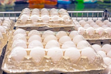 Süpermarketteki karton kaplarda beyaz tavuk yumurtaları. Dünya krizi