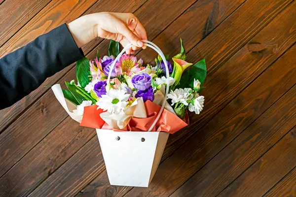 Beyaz kasımpatı ve güllerle dolu pembe bir çiçek sepeti ver. Tebrikler.