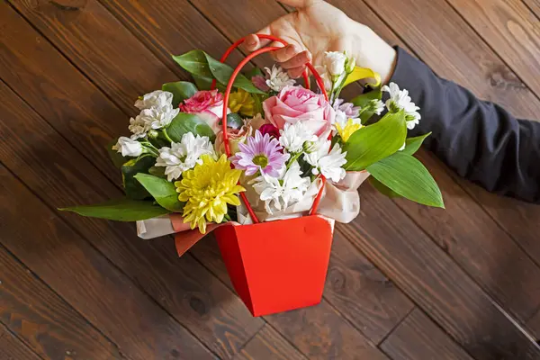 Beyaz kasımpatı ve güllerle dolu kırmızı bir çiçek sepeti ver. Tebrikler.