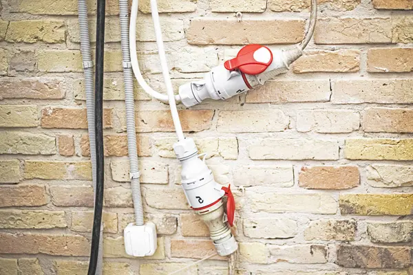 İç kısımda adaptörlerle tuğla döşenmiş kablolar. güvenli kullanım