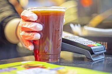 Tek kullanımlık plastik bardakta geri dönüşümlü, soğutulmuş bira ya da eldivenli kvass satılır. sokak yemekleri