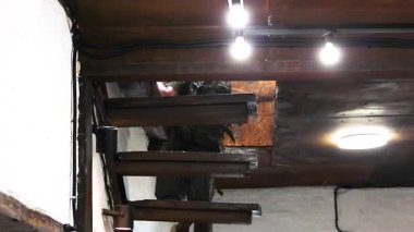 Askeri üniformayla dik tahta bir merdivenden dikkatlice iniyor..