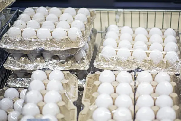 Süpermarketteki karton kaplarda beyaz tavuk yumurtaları. Ekonomik kriz