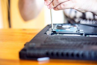 Tornavidayla vidayı sök ve arızayı gidermek için dizüstü bilgisayarın tabanını kaldır.