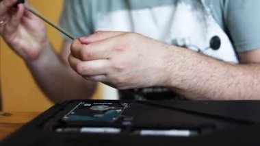 Elektrikli süpürgeyle dizüstü bilgisayarın tozunu temizlemek..