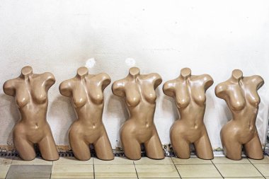 torso female mannequins in a row near the wall. Fashion industry