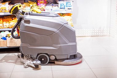 Rafların yakınındaki bir süpermarkette ürünlerle birlikte temizlik makinesi.