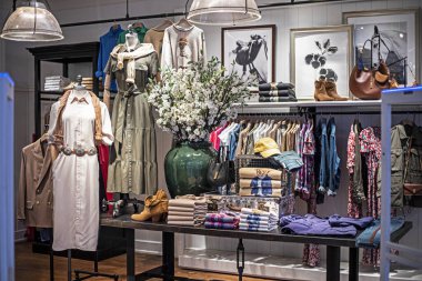 Bir butiğin içinde şık kadın ve erkek kıyafetleri var.