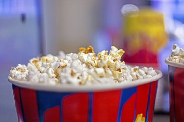 Sinema gişesinin yanında patlamış mısır için tek kullanımlık bardaklar. Aile hafta sonu. Geri dönüşümler