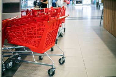 Süpermarketin girişine yakın ürünler için kırmızı plastik seyahatler