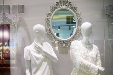 Ayna oyması ve iki hafif mankenle aydınlık bir iç mekan. Moda ve tarz