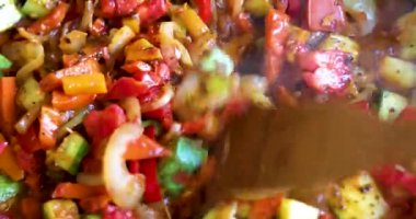 Sebze yağı ve sarımsak içinde ahşap bir spatula ile sebze güveci pişirip karıştırmak. Vejetaryen yemeği, sağlıklı yemek..