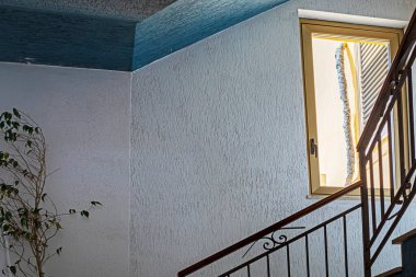 Köşesinde incir ağacı olan üç katlı bir apartmanın parlak giriş salonu.