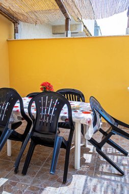 Katlanmış plastik sandalyeli teras ve Sicilya 'da bir masa.